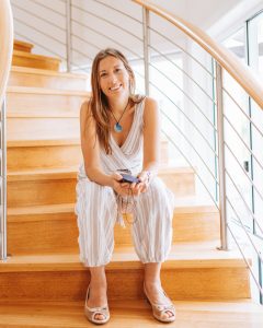 Nadia K sitting on stairs with Tesla in hands