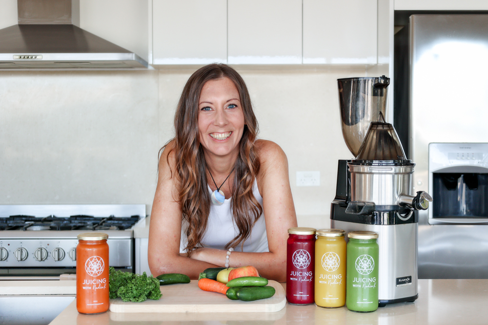 Nadia at kitchen bench with juices and a Kuvings Juicing Machine